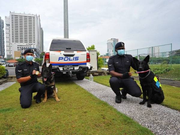 Dari kanan: Lans Koperal K. Thiru bersama Mailo dan Lans Koperal Calvin Maluni bersama Barny yang menerima penghargaan Ketua Polis Johor, pada Khamis.