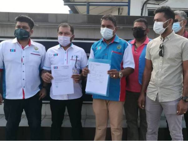 Ramesh (dua dari kiri) selepas membuat laporan polis di IPD Ipoh di sini pada Khamis.