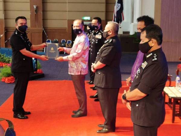 Wan Rosdy menyampaikan sijil penghargaan kepada pegawai dan anggota polis sebagai menghargai perkhidmatan cemerlang mereka pada Majlis Memperingati Hari Polis Ke-214 Peringkat Kontinjen Pahang pada Khamis.