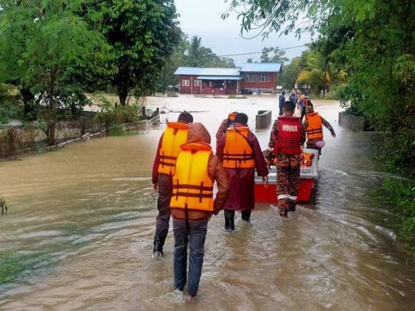 Anggota bomba membantu memindahkan mangsa banjir di Kampung Pandan 2 di sini selepas banjir melanda kawasan itu pada Rabu. - Foto Ihsan JBPM Pahang)
