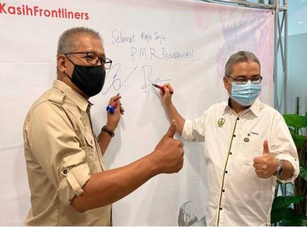 Datuk Bandar Ipoh Datuk Rumaizi Baharin (kanan) bersama Pengarah Jabatan Penerangan Perak, Mohd Taip Ubah (kiri) menurunkan tandatangan pada Program Signature Pusat Maklumat Rakyat di UTC Perak hari ini. - Foto Bernama