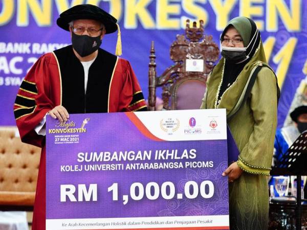 Hasnida (kanan) menerima diploma dan sumbangan ikhlas daripada PICOMS disampaikan Zulkifli pada Majlis Konvokesyen Kolej Universiti Antarabangsa PICOMS (PICOMS) kali ke-11 di Menara Bank Rakyat, Kuala Lumpur pada Sabtu.