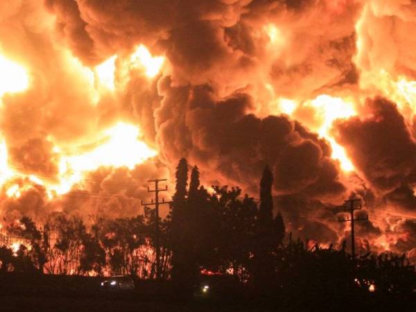 Asap tebal dan api marak kelihatan akibat kebakaran di loji penapisan minyak Pertamina di Balongan, Indramayu, Indonesia pada Isnin. - Foto EPA