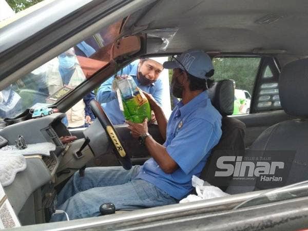 Hanif menyampaikan bantuan kepada pemandu teksi dan e-hailing secara pandu lalu di tempat letak kereta Jeti Semeling di sini pada Isnin.