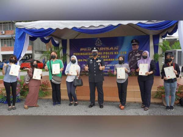 Sebahagian 12 petugas media menerima sijil penghargaan daripada A Asmadi pada Perbarisan Peringatan Hari Polis ke-214 peringkat IPD Ipoh pada Isnin.