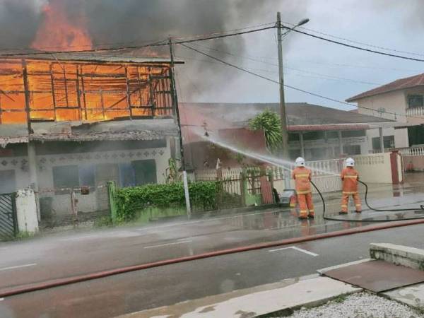 Anggota bomba memadam kebakaran melibatkan dua buah rumah di Kampung Baru 1, Tangkak.
