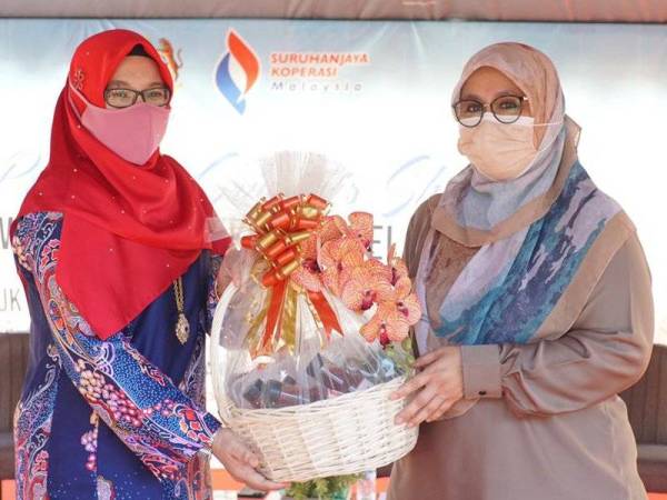 Mas Ermieyati (kanan) menerima cenderahati daripada Ketua Projek Sriwanis Shop, Nor Aina Zakaria di Peringat, Kota Bharu pada Isnin.