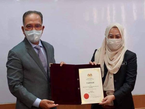 Wan Rosdy menerima sijil kelulusan Kuipsas sebagai universiti disampaikan Dr Noraini dalam satu majlis di Putrajaya pada Isnin. - Foto Facebook Wan Rosdy Wan Ismail