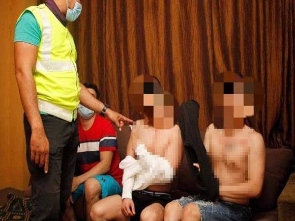 Antara individu yang ditahan dalam serbuan di sebuah pusat urut yang menawarkan khidmat seks sejenis di Cheras, Kuala Lumpur pada Isnin. - Foto DBKL