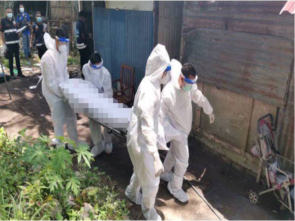 Anggota polis membawa keluar mayat mangsa untuk dibedah siasat.