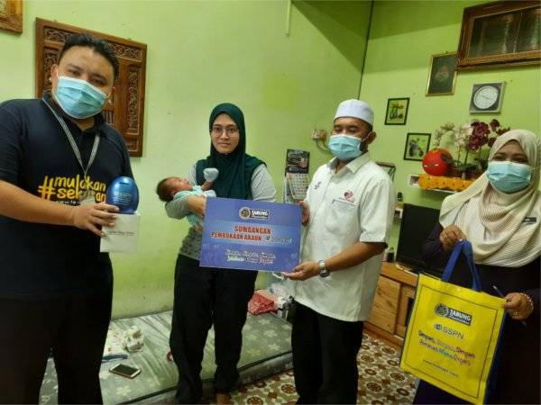 Nurul Hidayah (dua dari kiri) menerima replika pembukaan akaun SSPN-i yang ditaja Mohd Tarmizi (dua dari kanan) pada Pelancaran SSPN-i DUN Panching kepada ibu bersalin di Kampung Permatang Badak, pada Selasa.