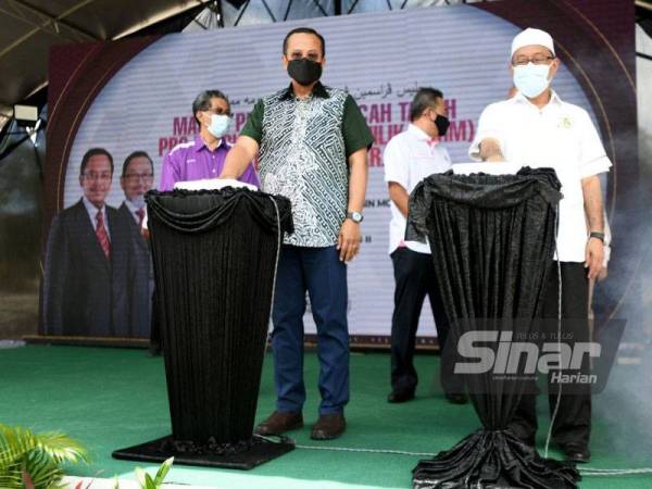 Dr Alias (kanan) mengiringi Dr Ahmad Samsuri menyempurnakan perasmian Majlis Pecah Tanah Projek Rumah Mampu Milik (RMM) Bukit Gasing II di sini pada Selasa.