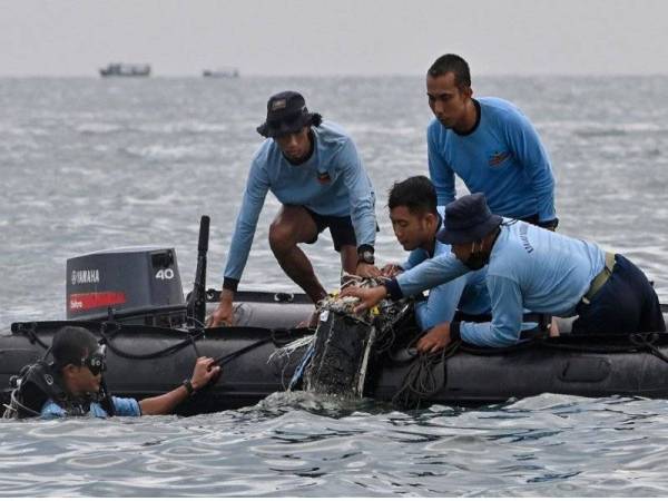 Gambar fail menunjukkan anggota-anggota tentera laut Indonesia menemui serpihan pesawat Sriwijaya Air dekat Pulau Lancang, Indonesia. - Foto AFP
