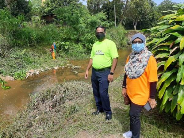 Veerapan dan Azuri semasa meninjau sungai Batang Benar selepas program gotong-royong membersihkan denai sungai di Kampung Batang Benar pada Khamis.