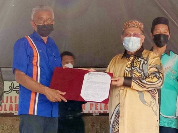 Mohd Amar (empat dari kanan) menerima sijil usahasama daripada Razali (kiri) semasa Pra Pelancaran Projek Solar Terapung dan Pengisytiharan Zon Idustri Akuakultur (ZIA) Tasik Danau Tok Uban, Pasir Mas.