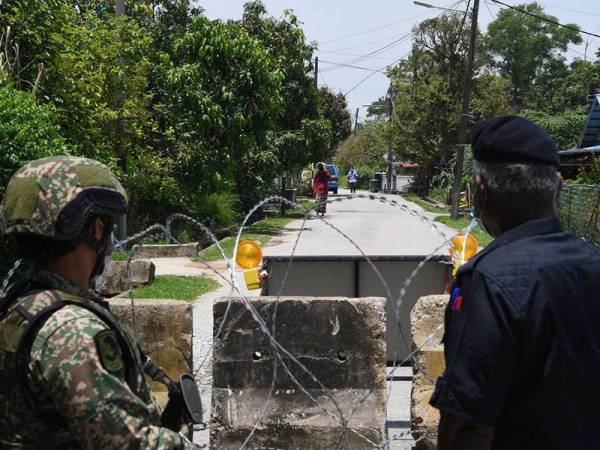 Petugas barisan hadapan Polis Diraja Malaysia (PDRM) dan Angkatan Tentera Malaysia (ATM) melakukan kawalan di sempadan Taman Guru dan Kampung SC yang dipasang dengan kawat duri selepas Taman Guru dikenakan Perintah Kawalan Pergerakan Diperketatkan (PKPD) bagi mengawal pergerakan penduduk selepas jumlah pesakit Covid-19 meningkat di kawasan ini ketika tinjauan fotoBernama dekat sini, hari ini.
