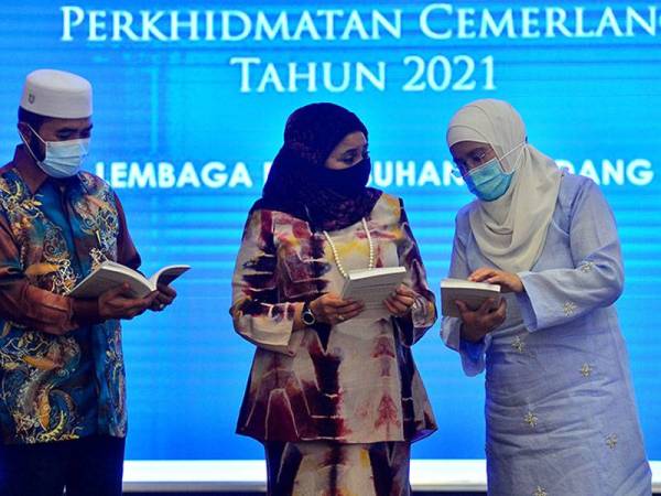 Haslina (tengah) bersama Nik Muhammad Zawawi dan Azulita meneliti buku CAMEL-T yang dilancarkan pada malam Rabu. Foto: Asril Aswandi Shukor