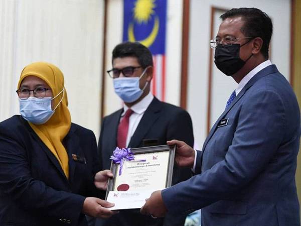 Abdul Rahman menyerahkan sijil penghargaan kepada salah seorang penerima APC Ketengah 2020 sempena majlis berkenaan yang diadakan di Balai Orang Ramai Bandar AL Muktafibillah Shah, Dungun pada Rabu.