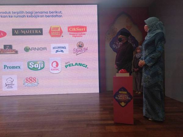 Rina (kanan) dan Ameer (kiri) melihat senarai produk yang terlibat dalam kempen Mydin.