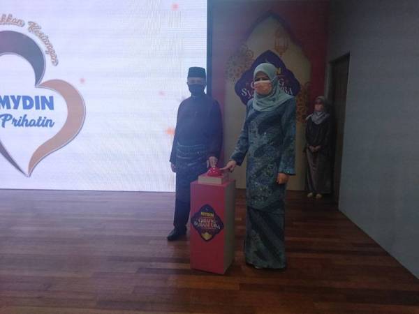 Rina (kanan) dan Ameer (kiri) membuat gimik pelancaran kempen ketika majlis yang berlangsung di Mydin USJ, Subang Jaya pada Khamis.