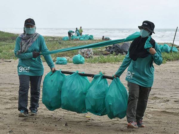 Sukarelawan Geng Plastik Ija (GPI) membawa sampah yang dikumpul ketika ditemui di Pantai Pandak.
