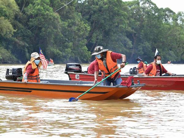 Peserta Ekspedisi Sungai Nerus, Kamal Jusoh, 48, (tengah) mengutip sampah yang terapung di sungai pada majlis Ekspedisi Sungai Nerus sempena Hari Air Sedunia 2021 di Kampung Tanjung Sabtu hari ini. 