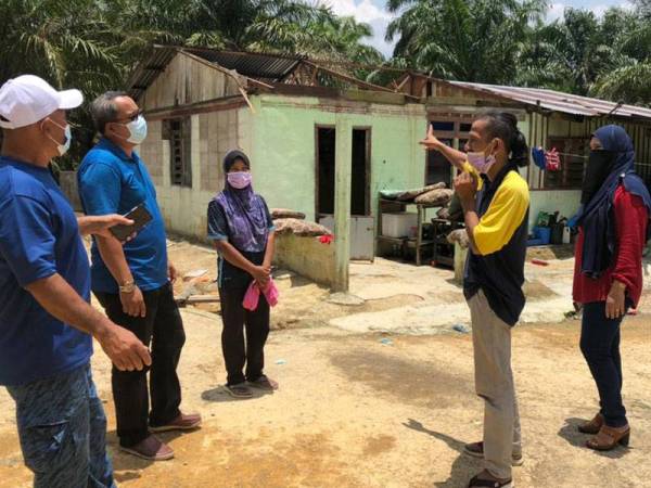 Shahrul Hisam (dua dari kanan) menunjukkan rumah sewanya yang rosak dipukul angin kencang di Kampung Shari, Simpang Renggam, Kluang, pada Sabtu.