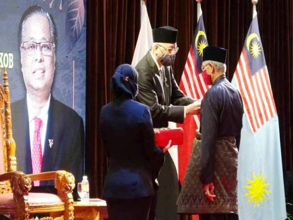 Ismail Sabri memakaikan pingat jasa kepada pesara tentera pada Majlis Penganugerahan Pingat Jasa Malaysia di Hotel Swiss-Bell Tanjung Lumpur, Kuantan pada Sabtu.