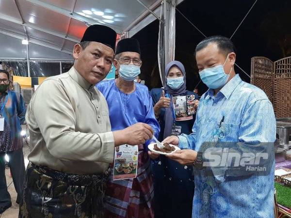 Aminuddin (kiri) merasa rendang di salah satu gerai hotel yang terlibat bufet Ramadan.