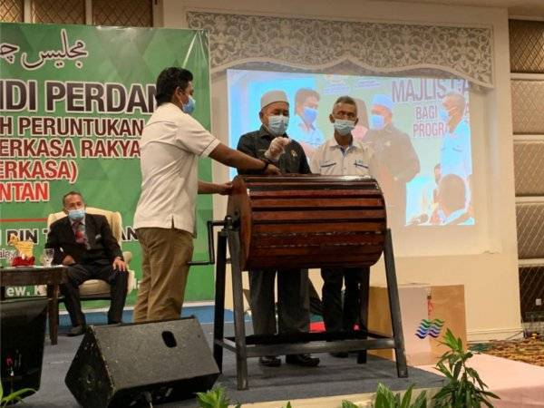 Tuan Ibrahim (tengah) semasa mencabut undi di Grand Riverview pada Ahad.