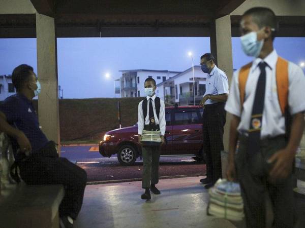 Pelajar kelihatan ceria semasa disambut guru ketika memasuki perkarangan sekolah bagi memulakan sesi persekolahan hari pertama bagi peringkat menengah di Sekolah Menengah Kebangsaan (SMK) Forest Height, Negeri Sembilan hari ini. - Foto Bernama
