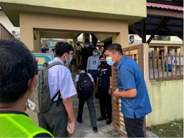 Mohd Radzi bertanya sesuatu kepada seorang pelajar ketika melawat Sekolah Menengah Kebangsaan Dato' Abu Bakar Baginda, Sungai Merab, Bandar Baru Bangi pada hari pertama pembukaan semula sekolah menengah pada Isnin.