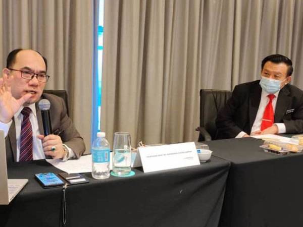 Mohammad Shatar (kiri) memberi penerangan mengenai sistem jaminan kualiti pengajian tinggi kepada pengurusan tertinggi UMS sambil diperhatikan Taufik (kanan).