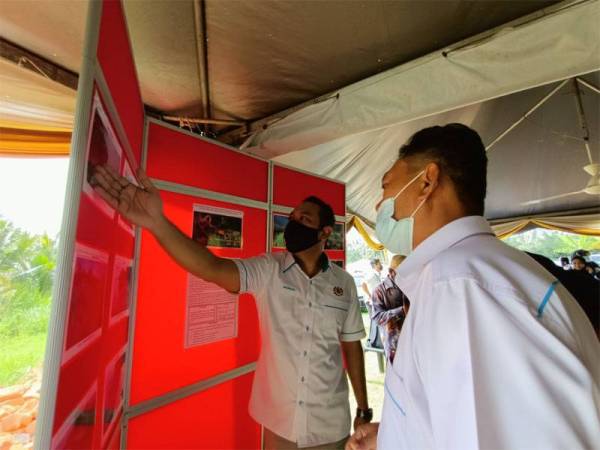 Ahmad Masrizal (kiri) melihat paparan Rancangan Pemuliharaan Sungai Perak dari Teluk Penikam ke Muara Sungai Perak di Bagan Datuk yang dianggarkan bernilai RM60 juta.