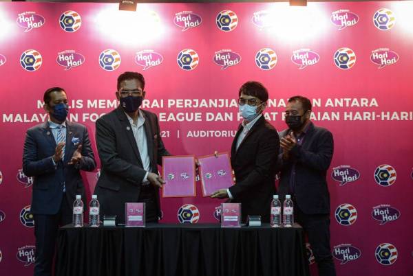 Ab Ghani (dua, kiri) menunjukkan kontrak perjanjian bersama Pengarah Pusat Pakaian Hari Hari Sdn Bhd, Syed Mohamed Sani Syed Kamarullbahrim (dua, kanan) pada Majlis Memeterai Perjanjian Penajaan antara MFL dan Pusat Pakaian Hari Hari di Wisma FAM pada Selasa. - Foto Bernama