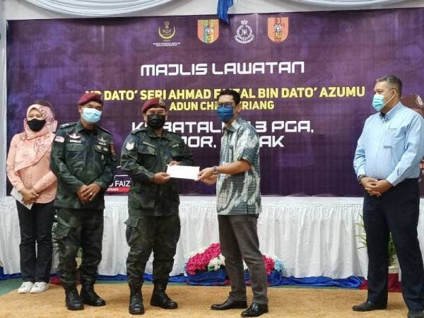 Ahmad Faizal (dua dari kanan) menyampaikan sumbangan kepada Sarjan Norihan Tari yang cedera parah dalam insiden tembakan dengan kumpulan penyeludup di sempadan Malaysia-Thailand, tahun lalu sempena penyampaian sumbangan kepada warga Batalion 3 PGA di Mes Pegawai Kanan Batalion 3 PGA Bidor, Tapah pada Rabu.