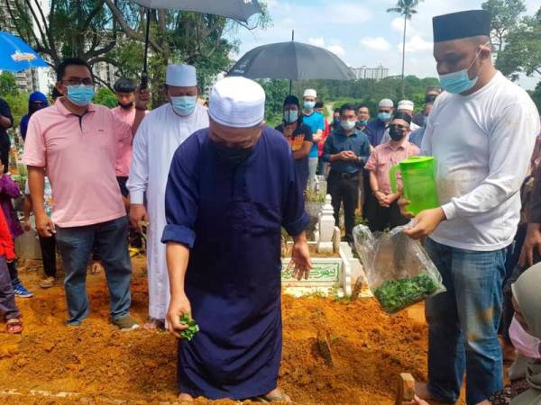 Hashim Mohd Yusoff, 65, menyiram air mawar ke atas pusara isterinya yang juga pelakon drama Noryati Taib, di Tanah Perkuburan Islam Kebun Teh hari ini. - Foto Bernama