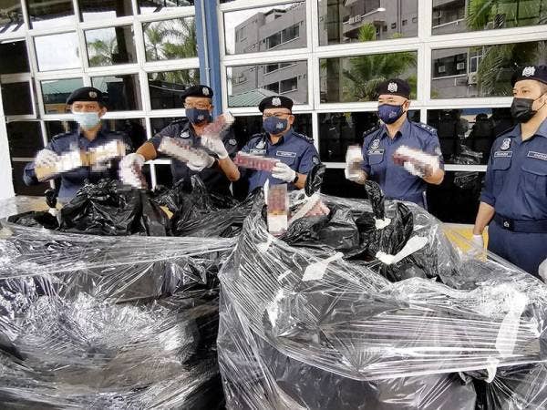 Abdul Latif Abdul Kadir (tengah) menunjukkan antara rokok seludup yang dirampas dalam serbuan di dua lokasi di Marang dan Kuala Nerus pada pada 31 Mac lalu.