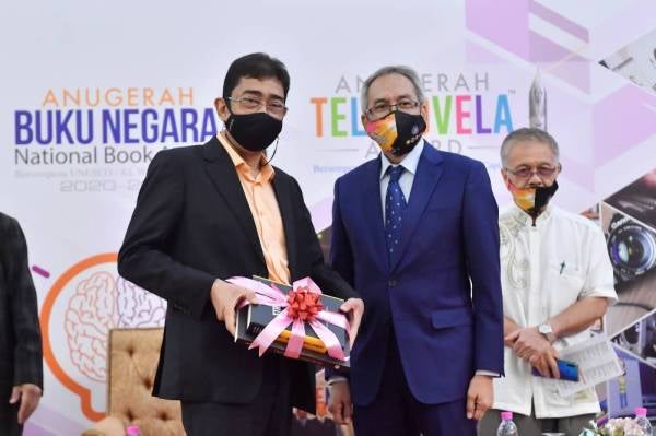 Zahidi menerima cenderahati daripada Ahmad Zaki pada Pelancaran Speaker Corner dan Radio Buku FM sempena Persidangan Industri Kreatif Kebangsaan 2021 di Pusat Dagangan Dunia Kuala Lumpur pada Rabu. - Foto Bernama