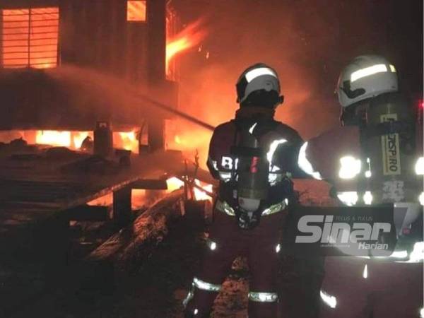 Anggota bomba memadamkan kebakaran membabitkan dua kontena dalam kejadian di sebuah pelantar ikan di Pantai Redang, Sekinchan pada lewat malam Rabu.
