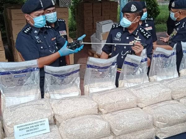 Razarudin (kanan) menunjukkan antara dadah yang dirampas ketika sidang akhbar di Balai Polis Pelabuhan Klang pada Khamis.