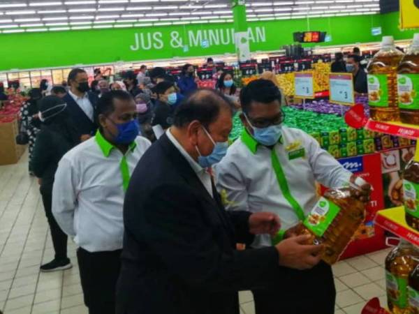 Tunku Imran (tengah) melihat produk ditawarkan di Giant selepas merasmikan wajah baharu pasar raya itu di Giant Kota Damansara pada Khamis.