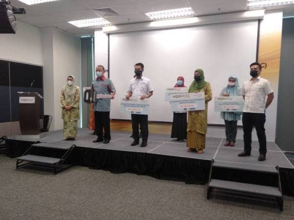 Saipolyazan (tiga dari kiri) bergambar bersama Norazlina (tiga dari kanan) selepas Majlis Penyampaian Agihan Zakat Worldwide Holdings yang berlangsung di Mercu Worldwide, di Shah Alam pada Khamis.