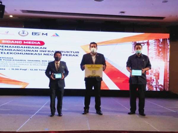 Khairul Shahril (tengah) menunjukkan papan Maklumat Struktur Telekomunikasi selepas hadir ke majlis Taklimat Pelaksanaan Penambahbaikan Pembangunan Infrastruktur Telekomunikasi Negeri Perak di sebuah hotel di sini pada Khamis.