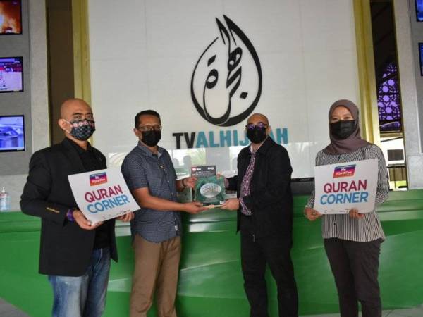 Saifulizan (dua kiri) menjadi wakil TV Alhijrah menerima tiga set al-Quran Wakaf untuk Ummah daripada Megat Zamzuri (dua kanan).