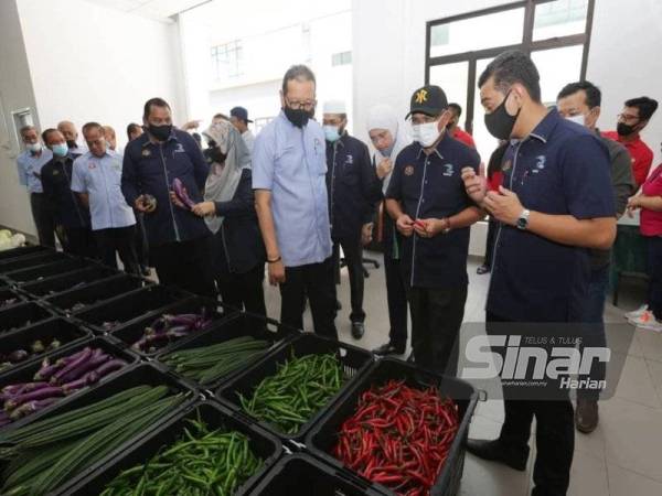 Ronald (dua dari kanan) mendengar penerangan mengenai hasil pertanian.