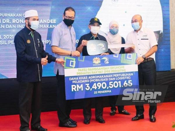 Ronald (tiga dari kanan) menyampaikan simbolik kunci untuk 22 buah lori sejuk beku kepada Pertubuhan Peladang seluruh negara.