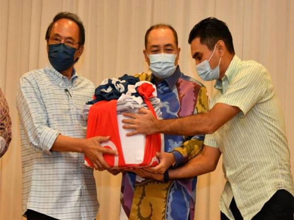 Hajiji menerima 10,000 borang permohonan untuk menyertai Bersatu daripada Ketua Zon 5 Bersatu, Datuk Zakaria Edris (kiri) dalam majlis bersama pemimpin Parti Pribumi Bersatu Malaysia (Bersatu) di Sandakan.