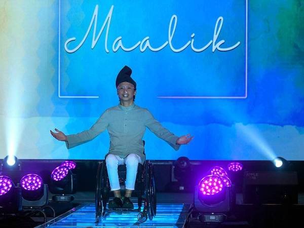 Orang Kurang Upaya Nur Azhar Idham yang mengalami kecederaan saraf tunjang memperagakan busana rekaan Nurita Harith pada Majlis Pelancaran Perkeso 'Functional Adaptive Clothing' yang disempurnakan oleh Raja Permaisuri Agong Tunku Hajah Azizah Aminah Maimunah Iskandariah hari ini.