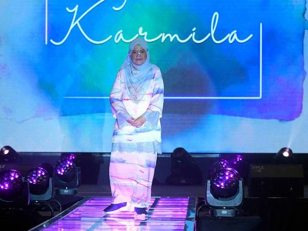 Orang kelainan Upaya (OKU) Sri Thuraiya Mohd Ali yang menghidap strok memperagakan pakaian rekaan Nurita Harith pada Majlis Pelancaran Perkeso 'Functional Adaptive Clothing' yang disempurnakan oleh Raja Permaisuri Agong Tunku Hajah Azizah Aminah Maimunah Iskandariah hari ini. 